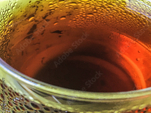 Cold peach iced tea seen from inside the glass