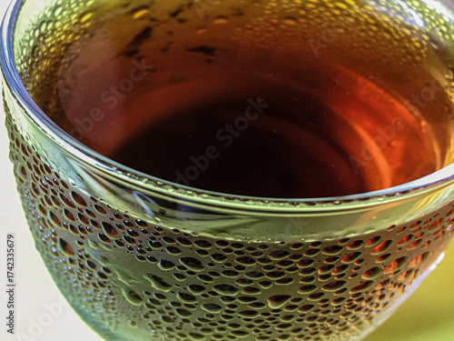 Cold peach iced tea seen from inside the glass