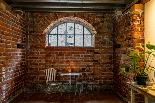 Photography Stockholm, Sweden A brick cafe interior with a table and chairs and a portico window