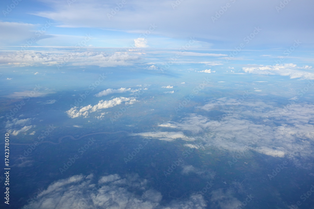 Fototapeta premium Beautiful white clouds drifting peacefully in the blue sky as seen from above or Layers of soft clouds stretching across the sky during a daytime flight.