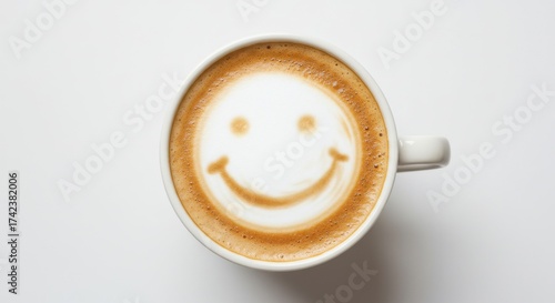 Cup of coffee topped with milk foam art featuring a smiley face, on a light background