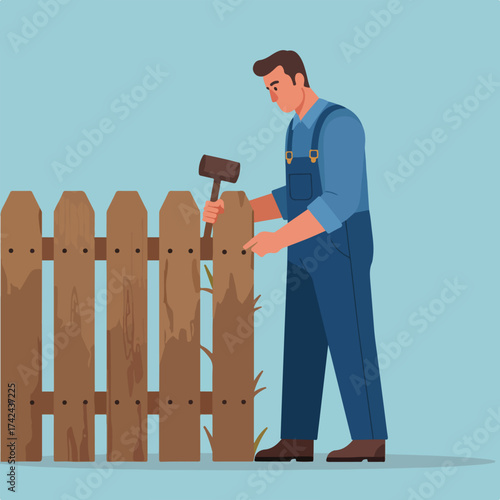 Man in overalls hammering wooden fence posts