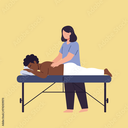 Person receiving back massage on table from therapist