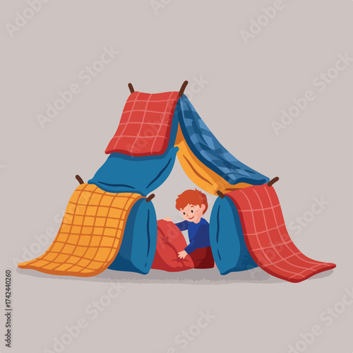 A young child happily plays in a homemade fort of blankets and pillows