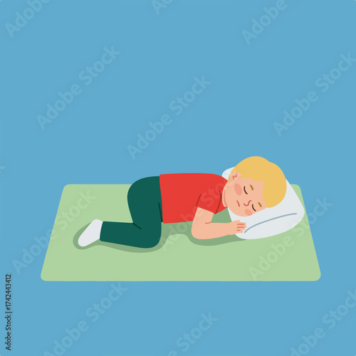 A young person sleeps soundly on a pillow on a mat