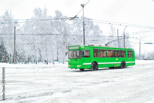 Bright Green Trolleybus on a Snowy Winter Street ,Eco-Friendly Public Transport in Urban Landscape with Frost-Covered Trees, Electric Bus in Cold Weather, Sustainable City Mobility,  Energy Concept