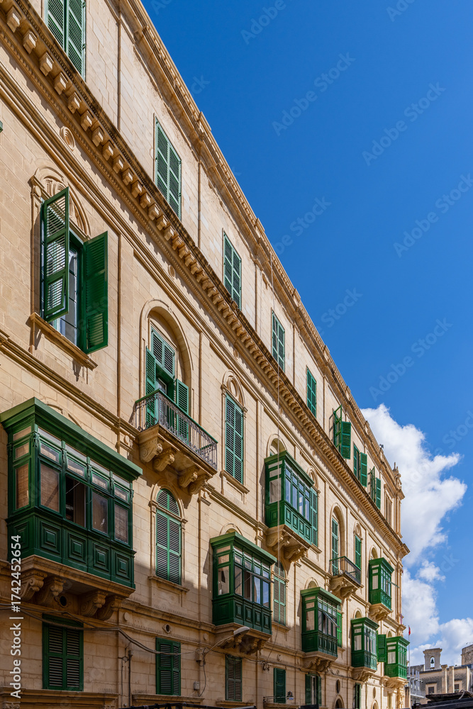 Naklejka premium Green Traditional Maltese Balconies on Sunlit Historic Building