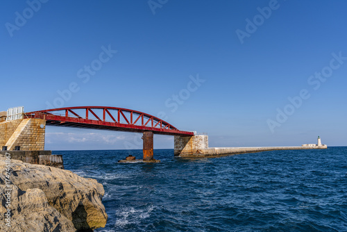 Iconic Red Bridge and Lighthouse Over Blue Mediterranean Sea, Malta