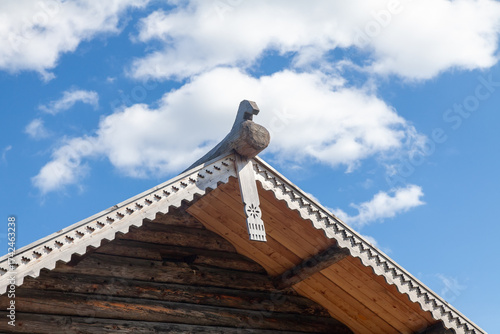 Roof of a russian wooden house featuring a carved ridge and decorative eaves