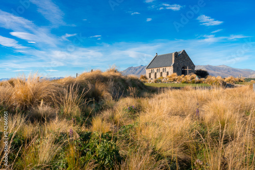 Church of the Good Shepherd at golden hour sunset, Lake Tekapo, New Zealand with illuminated tussock grass