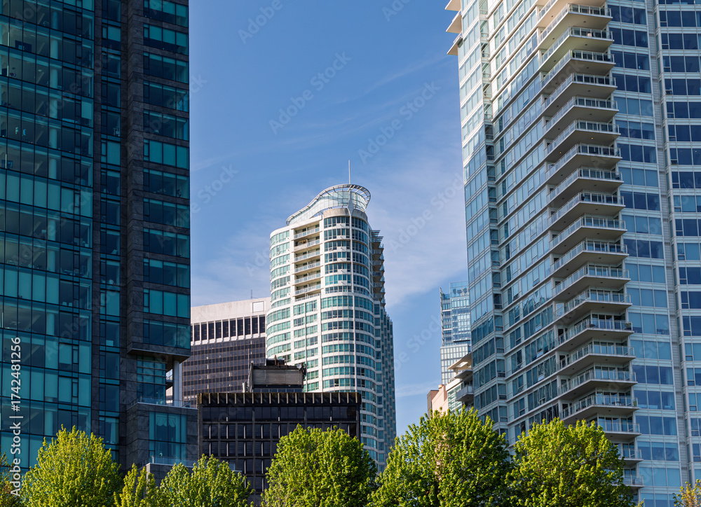Obraz premium Skyscrapers and greenery create a vibrant cityscape on a clear day in downtown Vancouver with bright blue sky