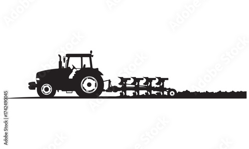 Black Silhouette of a Tractor Plowing a Field with a Modern Cultivator