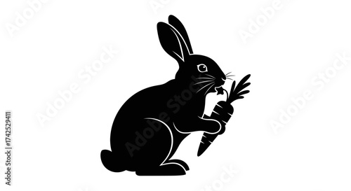 Black silhouette of a rabbit holding a carrot in its paws.