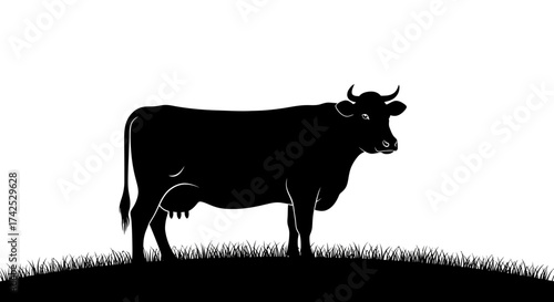 Silhouette of a majestic cow standing gracefully on grassy terrain, a bovine beauty.