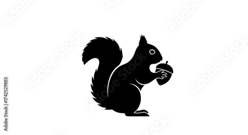 Silhouette of a squirrel holding an acorn, black and white image.
