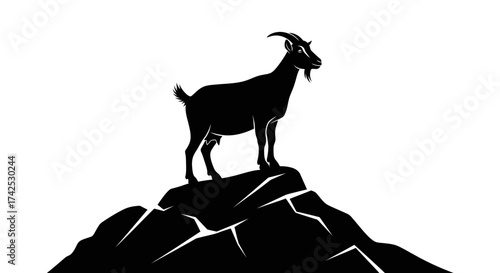 Silhouette of a Goat Standing Atop a Rocky Peak.