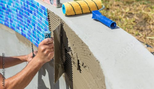 Foto A man lays mosaic tiles in a swimming pool. Selective focus.