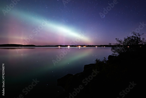 Amazing aurora borealis dancing over calm lake in >Farnebofjarden national park in  north of Sweden.