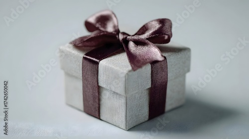 An elegant gift box tied with a satin ribbon bow presented against a soft neutral background