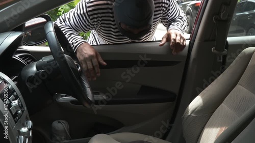 Masked thief stealing briefcase from inside car, symbolizing crime, theft, and loss. Concept of security awareness, vehicle safety, and prevention of property theft in daily urban environments