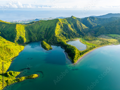 Lagoa do Fogo Lake on Sunny Morning. Green Lush Hills, Mountains and Atlantic Ocean. Azores, Sao Miguel Island. Portugal. Aerial Drone Shot