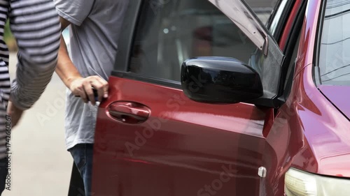 Open car door with man walking away holding briefcase after robbery, concept of crime, danger, theft, and security awareness. Represents the aftermath of a carjacking or street crime situation
