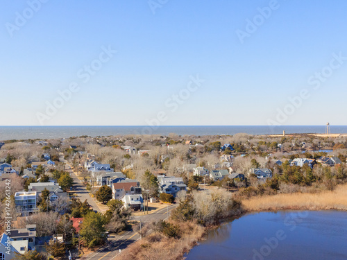 Scenic view of a coastal community with houses, water, and clear blue skies during midday