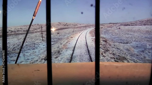 Locomotive Window View at Sunset With Snowy Landscape and Car Light in Distance, Patagonia, Argentina 