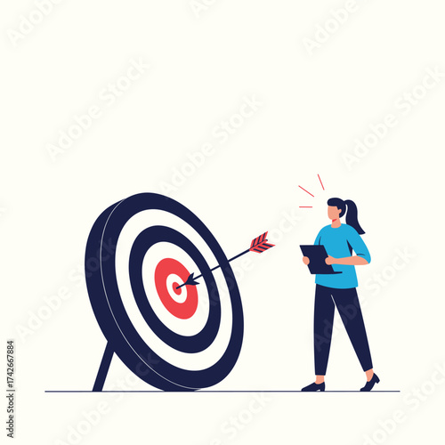 Woman assessing the archery target after hitting the bullseye.