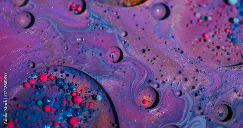 Dye bubbles. Paint wave. Defocused purple pink blue colorful droplet glitter oil acrylic liquid floating on abstract art background.