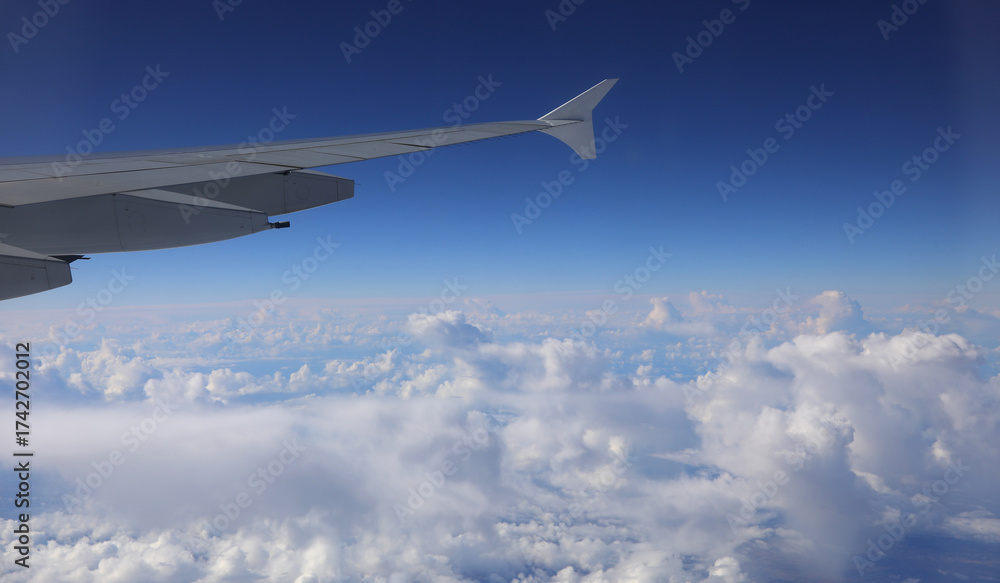 Obraz premium clouds at 40000 feet elevation from the plane looking at a part of the wing