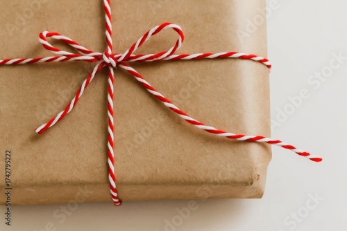 A beautifully wrapped gift tied with red and white striped ribbon, symbolizing a thoughtful present