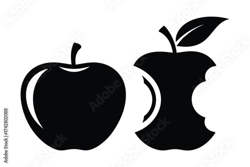 A whole apple sits near a bitten apple core with a leaf