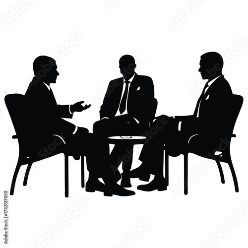 Silhouetted businessmen converse around a small table during a serious discussion regarding business matters