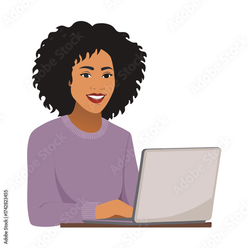 Smiling woman with afro hairstyle types on her laptop and looks forward