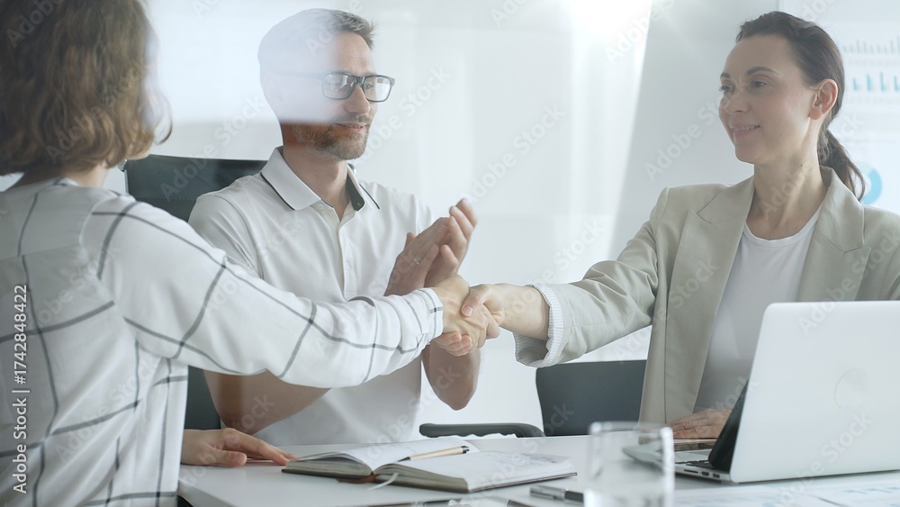 Obraz premium Businesswomen partners are shaking hands after successful negotiation, colleagues clapping, celebrating agreement in modern office headset. Handshake concept