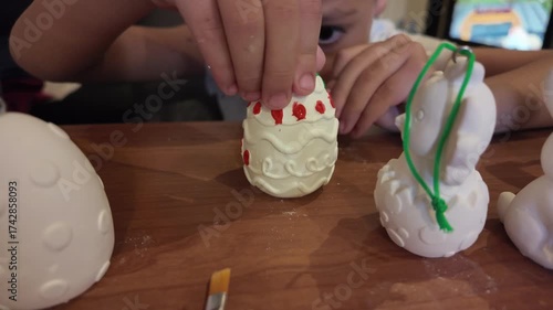 A child coloring gypsum egg for easter. High quality 4k footage