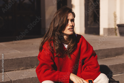 Fotografija Tired exhausted fatigued brunette long hair woman waiting meeting sad disappointed, businesswoman in city sitting stairs stairway suffer stress, wear red sweater, bad news,  problems