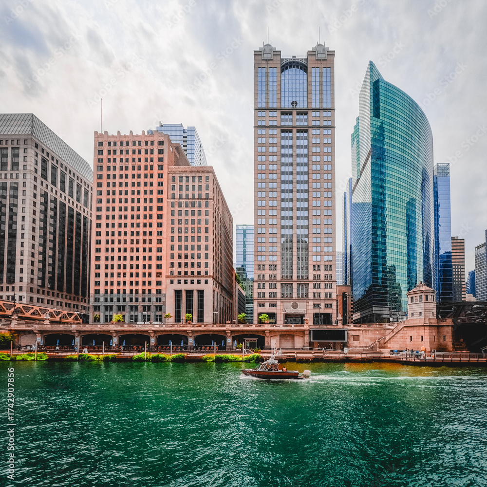 Fototapeta premium Majestic skyscraper buildings on the Chicago River in Chicago, Illinois. Mix of modern and historical architecture Located within the Financial District in the Loop.