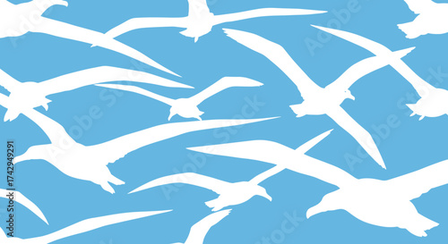 A flock of white seagulls in flight against a clear blue sky.