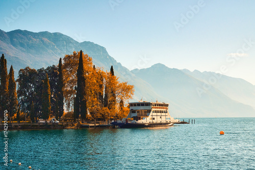 View of beautiful Lake Garda surrounded by mountains, Panoramic autumn view of sunset over Lake Garda in the evening with beautiful sunset colors, Italy