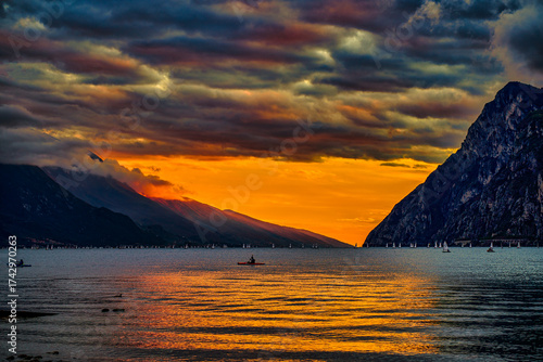 View of beautiful Lake Garda surrounded by mountains, Panoramic autumn view of sunset over Lake Garda in the evening with beautiful sunset colors, Italy