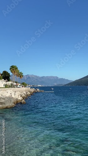 Landscape with turquoise water, palm trees, and mountains