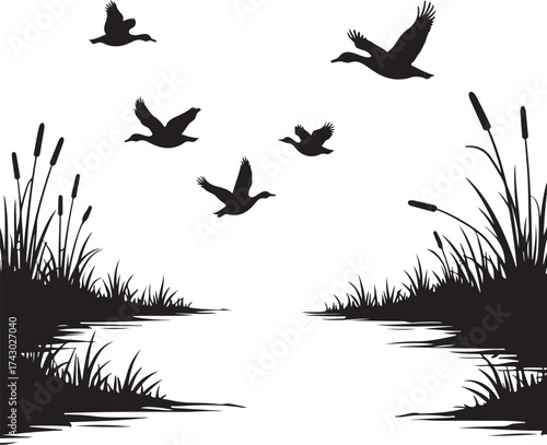 Black silhouette ducks flying over marsh grass and water