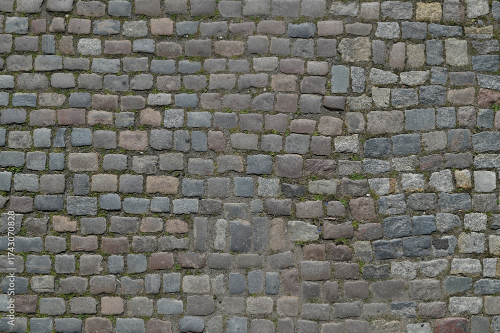 Fototapeta premium Background of cobblestone. Architecture background with stone cladding road. Concrete tiles background. Stone road background for poster or banner.