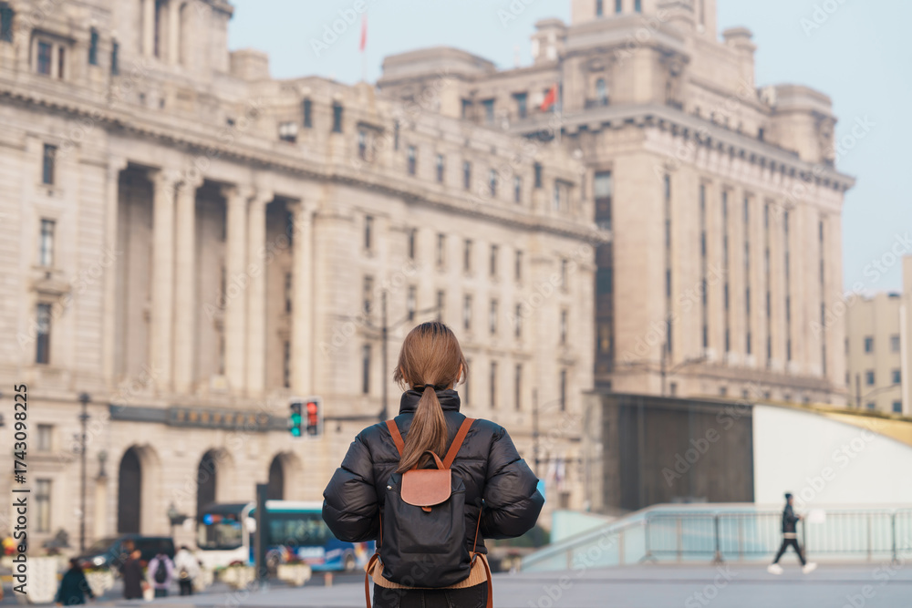 Obraz premium woman traveler visiting in Shanghai, China. Happy Female Tourist sightseeing Shanghai view in The Bund of Shanghai in Autumn season. landmark and popular for tourism attractions. Travel and Vacation