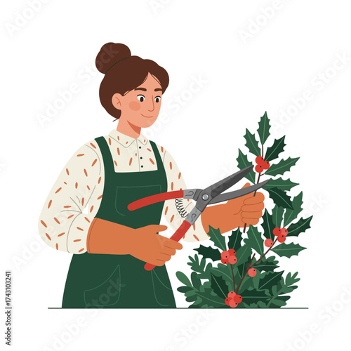 A woman with her hair in a bun, wearing an apron and gloves, is pruning a holly bush with red berries using pruning shears.