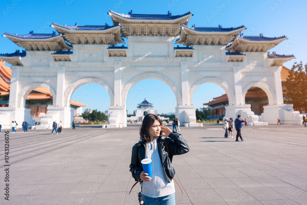 Fototapeta premium woman hand holding Pearl bubble milk tea glasses. traveler at National Chiang Kai shek Memorial, a famous beverages in Taipei, Taiwan