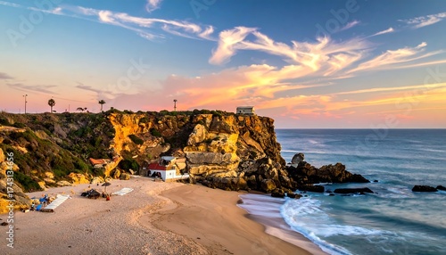 Coastal scene with beach, cliffs and buildings under sunset