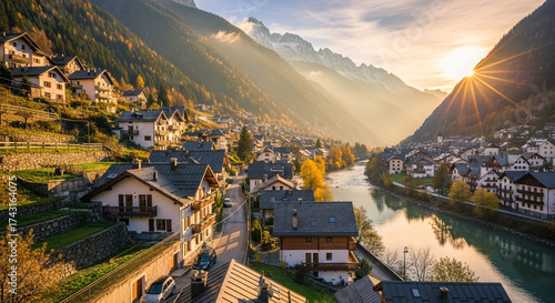 Beautiful view of courmayeur village in aosta valley, italy, with the sun shining over the mountains and houses in the valley creating a scenic landscape